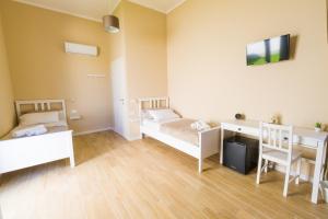 a room with two beds and a desk in it at Stabile Hospitality in Trapani