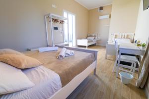 un grande letto in una stanza con scrivania e una camera da letto di Stabile Hospitality a Trapani