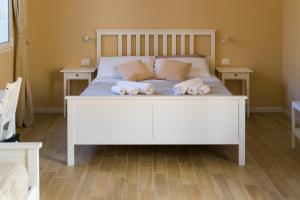 a bedroom with a white bed with towels on it at Stabile Hospitality in Trapani