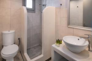 a bathroom with a toilet and a sink and a shower at Olive Tree Suites in Fira