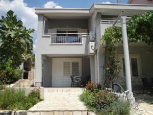 a white house with a porch and a balcony at Villa Marica in Neum