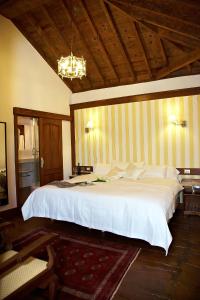 a bedroom with a large white bed with a wooden ceiling at Hotel Emblemático San Agustin in Icod de los Vinos