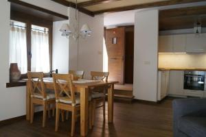 una cucina e una sala da pranzo con tavolo e sedie in legno di Acogedora casita en el Pallars a Isil Altre 22 foto