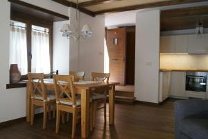 a kitchen and dining room with a wooden table and chairs at Acogedora casita en el Pallars in Isil
