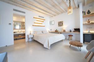 1 dormitorio blanco con 1 cama grande y baño en Myconian Crown Suites, en Kalafatis