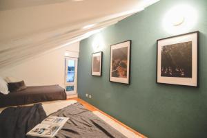 a bedroom with a green wall with pictures on it at Apartments Lucija in Zadar