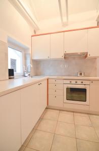 a white kitchen with white cabinets and a sink at Apartments Lucija in Zadar