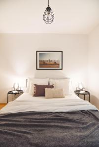 a bedroom with a large white bed with two lamps at Apartments Lucija in Zadar