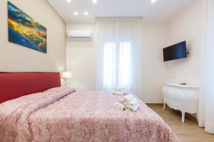 - une chambre avec un lit rose et une télévision dans l'établissement Sorrento Sweet Sirena 2, à Sorrente