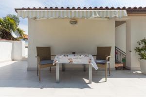 een tafel en stoelen op een patio met een luifel bij Apartments Janko in Rovinj