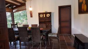 une salle à manger avec une table, des chaises et une horloge dans l'établissement Hermosa Casa Campestre en Villeta, à Villeta