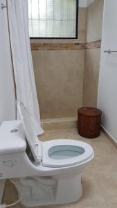 La salle de bains est pourvue d'une douche et de toilettes blanches. dans l'établissement Hermosa Casa Campestre en Villeta, à Villeta
