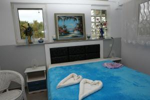 a bedroom with two towels on a blue bed at Villa Isabel in Rizá