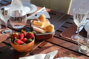 una mesa con una cesta de comida y un tazón de fresas en Casa Entre Mar y Monte en Ribas