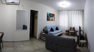 ein Wohnzimmer mit einem Sofa und einem Stuhl in der Unterkunft Guaruja - Enseada in Guarujá