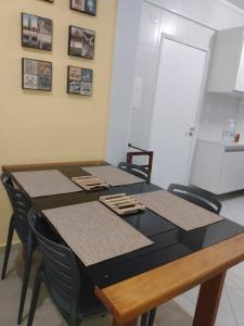 ein Esszimmer mit einem Tisch mit Stühlen und einem Tisch in der Unterkunft Guaruja - Enseada in Guarujá