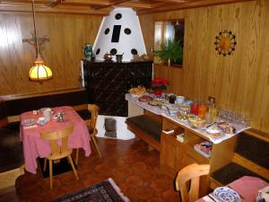 a dining room with a table and a vase on the wall at Garnì Conturina in Santa Cristina Gherdëina