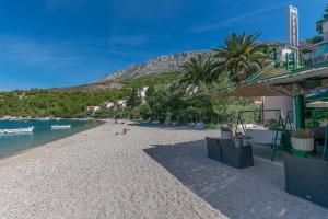 a beach with trees and a mountain in the background at Apartments Bluesun in Omiš