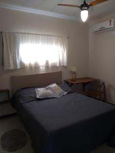 フロリアノポリスにあるEstúdio Sabiáのベッドルーム1室(青い毛布、窓付)