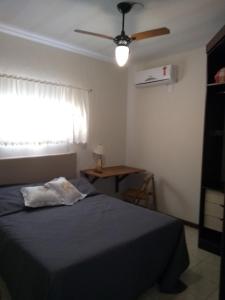 a bedroom with a bed and a ceiling fan at Estúdio Sabiá in Florianópolis