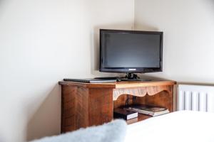 a small tv sitting on top of a wooden desk at The Honest Lawyer, Ascend Hotel Collection in Nelson