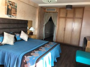 a bedroom with a bed with a blue comforter at Studiotel Afoud in Agadir