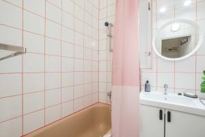 a bathroom with a tub and a sink and a mirror at Apartment Na Kozacce 6 in Prague