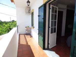 a door to the balcony of a house at Casa Margmar in Vila Nova de Milfontes