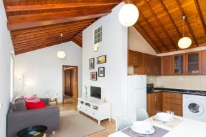 a living room with a couch and a kitchen at Quinta do Torcaz in Horta