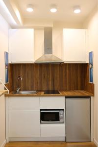 a kitchen with white cabinets and a sink at Casa Abi in Tirana