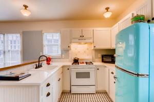 a kitchen with white cabinets and white appliances at Colorado Chautauqua Cottages in Boulder