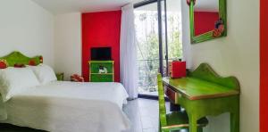 sypialnia z łóżkiem i oknem z telewizorem w obiekcie HOTEL EL PAN NUESTRO w mieście Tepoztlán