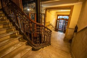 una escalera en una casa con barandilla de hierro forjado en High Hostel Rosario en Rosario