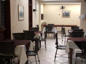 uma sala de jantar com mesas e cadeiras e um relógio na parede em Pousada Italia Beach em Aquiraz