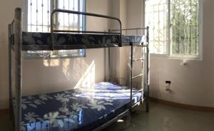 Łóżko piętrowe w pokoju z oknem w obiekcie Gregorio Homes w mieście Bauang