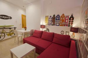 a living room with a red couch and a table at Apartamentos El Templo Suites in Mérida