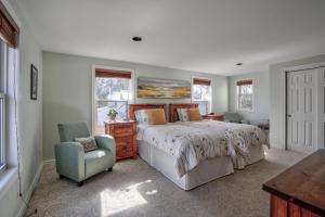ein Schlafzimmer mit einem großen Bett und einem Stuhl in der Unterkunft Finlay House Bed and Breakfast Niagara - on - the - Lake in Niagara on the Lake