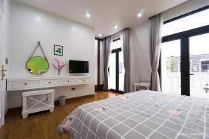 a bedroom with a large bed and a tv at Tropical Villa Halong in Ha Long