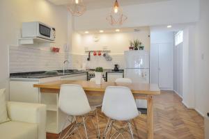 a kitchen with a wooden table and white chairs at Apartamento en el mejor sitio de Recoleta in Buenos Aires