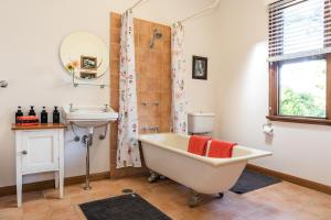 a bathroom with a tub and a sink at Sidneys Retreat in Katoomba