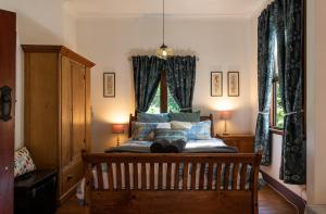 a bedroom with a bed with blue curtains and a window at Sidneys Retreat in Katoomba