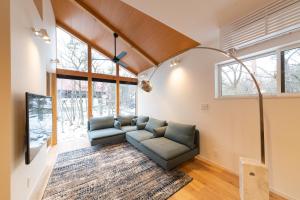 a living room with a couch and some windows at Black Crane Chalet by Hakuba White Fox Company in Hakuba