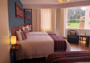 a hotel room with a large bed and a window at Chinchero Boutique Hotel & Tours in Chinchero