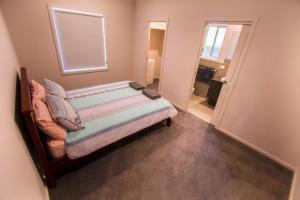 ein kleines Schlafzimmer mit einem Bett und einem Fenster in der Unterkunft Serene Shores in Wellington East