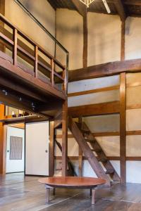 a loft bed with a bench in a room at carafuru Japanese Old House in Sado