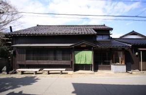a building with a bench in front of it at carafuru Japanese Old House in Sado