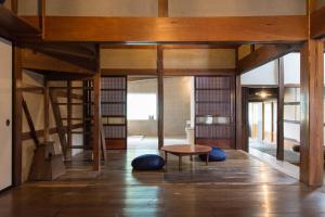 Habitación con mesa y suelo de madera. en carafuru Japanese Old House, en Sado