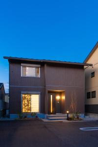 una casa marrón con un garaje delante en Yurian, en Kanazawa
