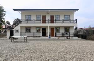 巴旺Gregorio Homes的一座白色的房子，前面有一张长椅