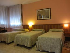 a hotel room with three beds in a room at Hotel Ristorante Al Bassanello in Bassano del Grappa